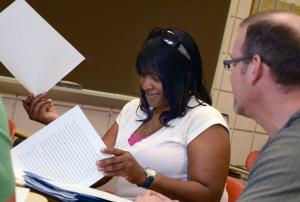 Teacher aids students in her research paper. Student and teacher dicussing a paper.