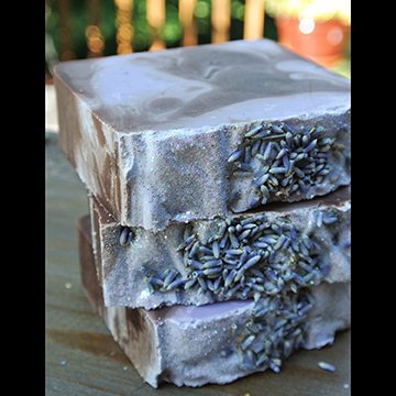 Three blocks of handmade soaps stacked on top of one another