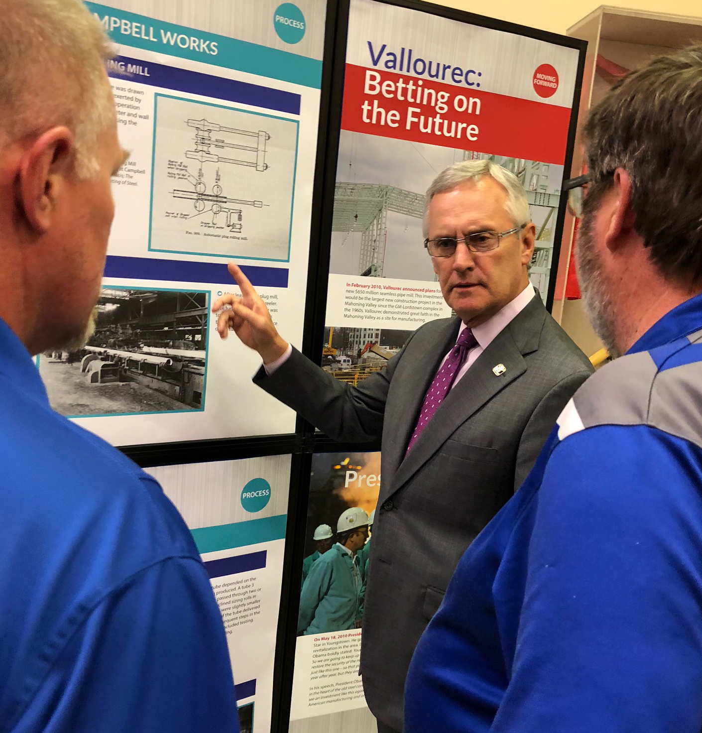 SU President Jim Tressel talks with employees of Vallourec at the new exhibit at the Youngstown Historical Center for Industry and Labor.