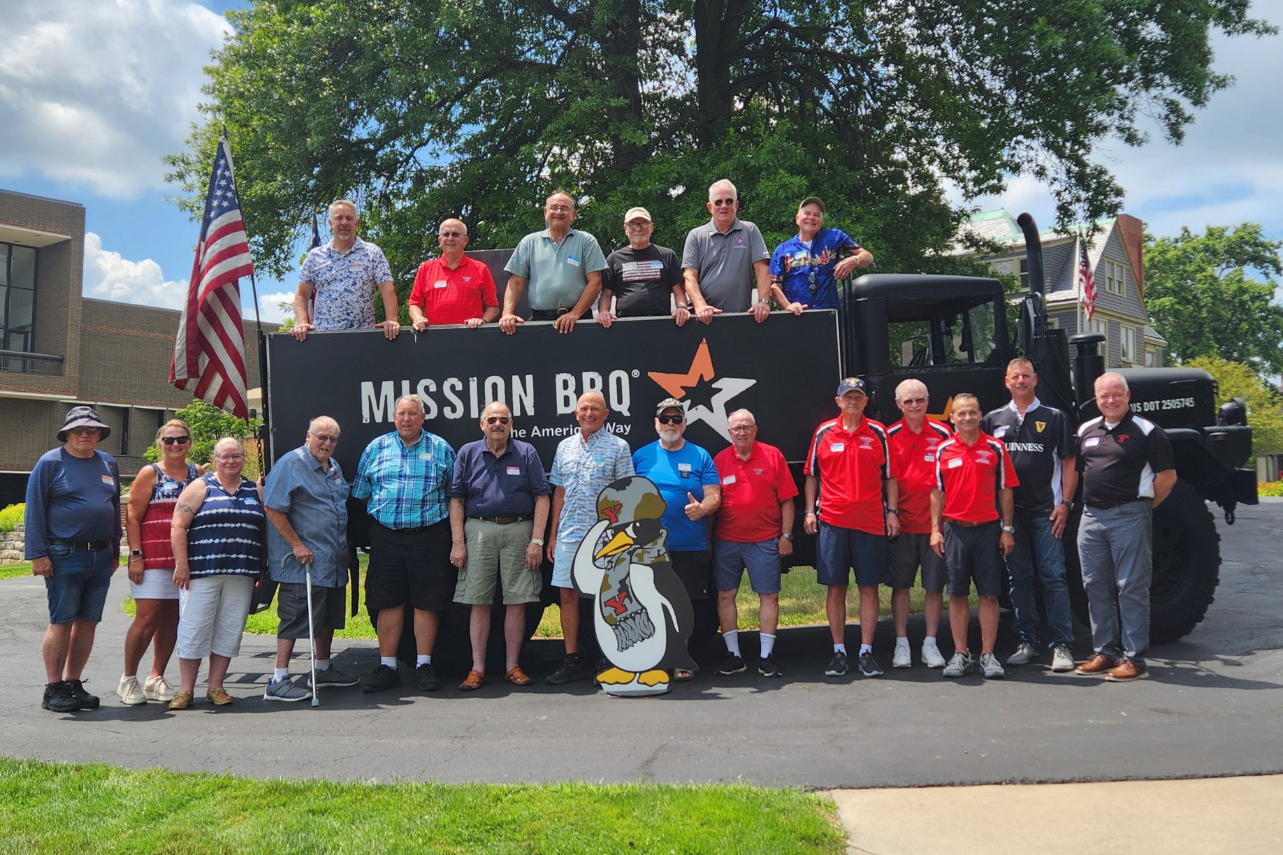 Attendees at the 10th annual YSU Army ROTC Alumni Picnic pose in front of a military vehicle from Mission BBQ