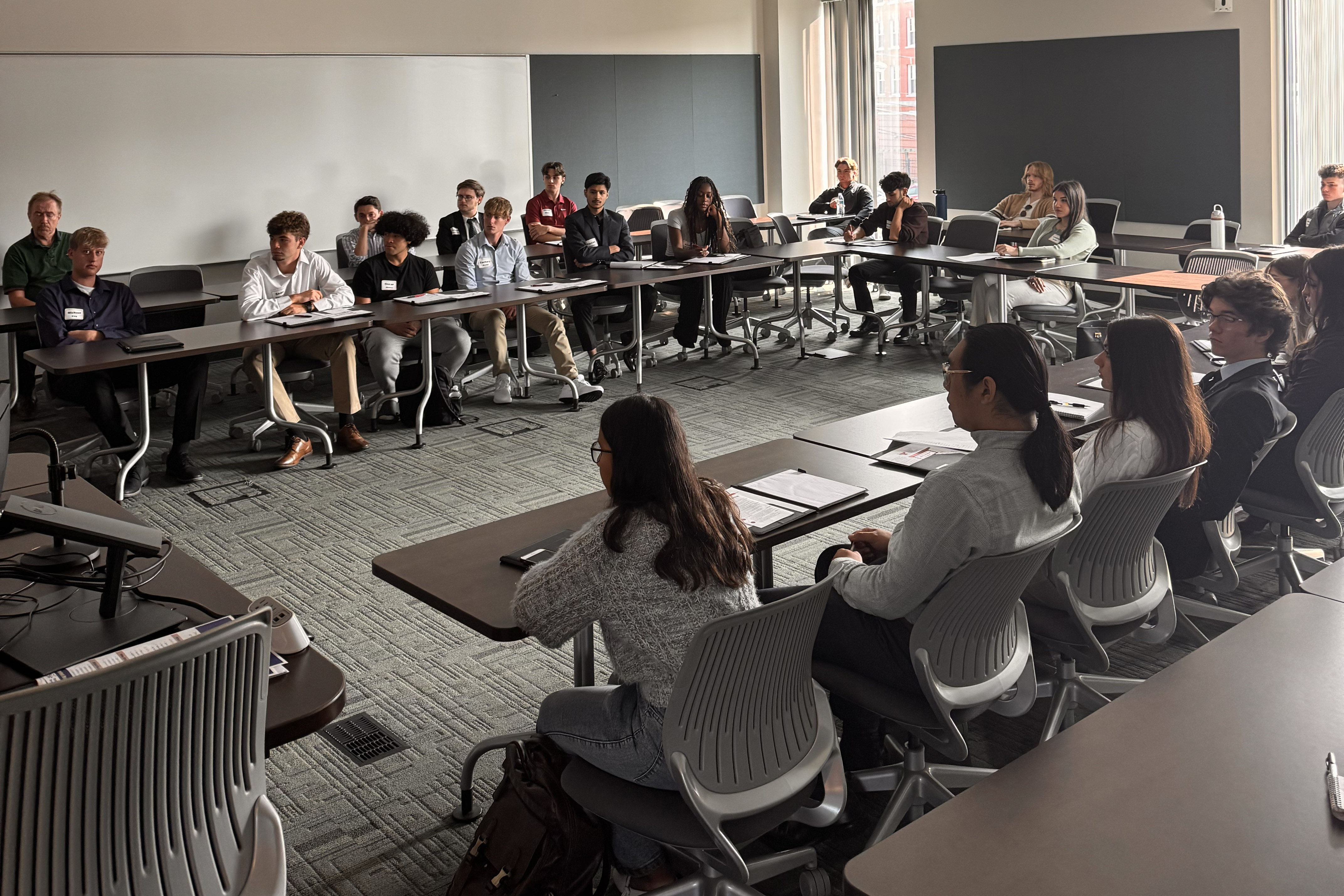 Students sit around a table in a conference room in Williamson hall as part of the Professional Development Summit
