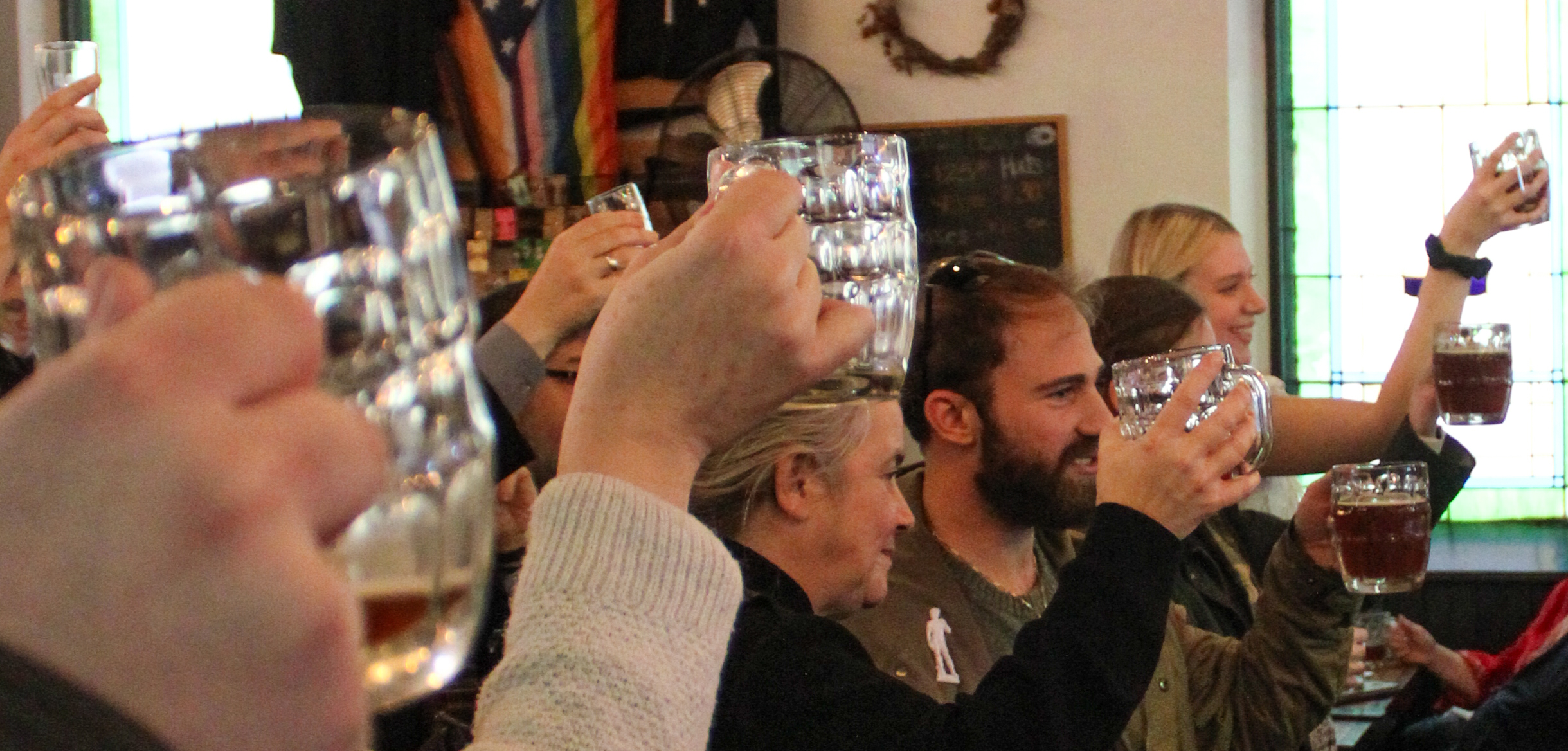 People raising their beer glasses in cheers at the event