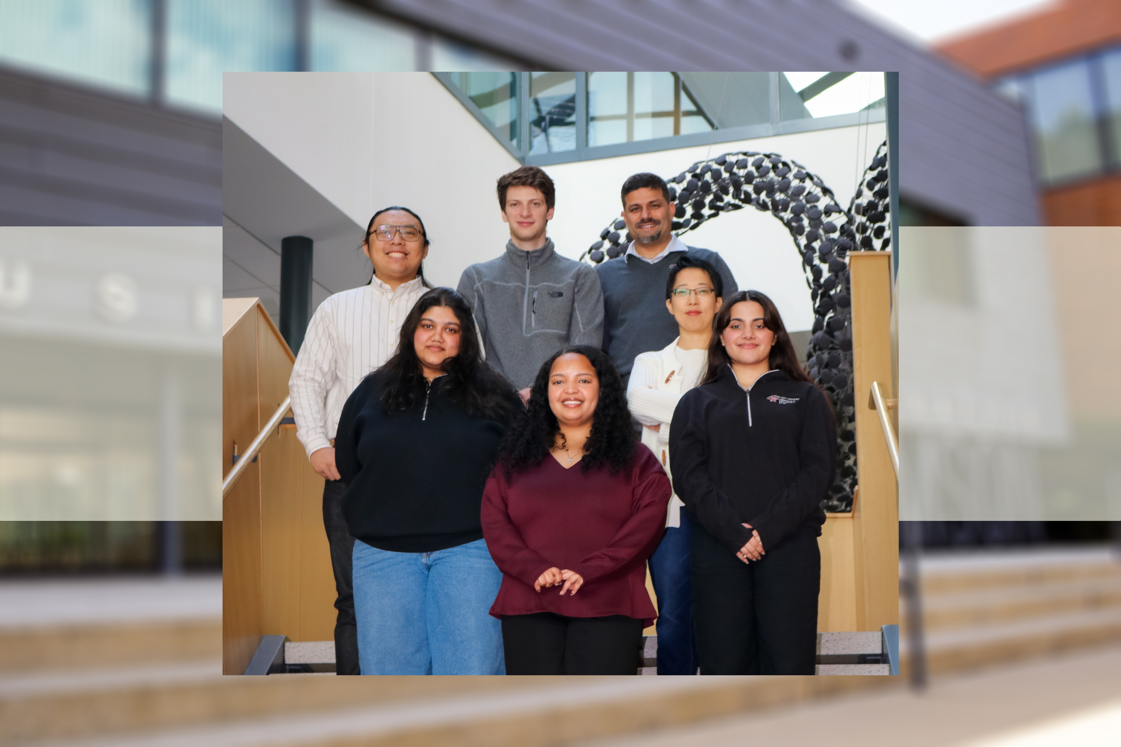 Penguin City Analysts team photo posing on the steps inside of Williamson Hall