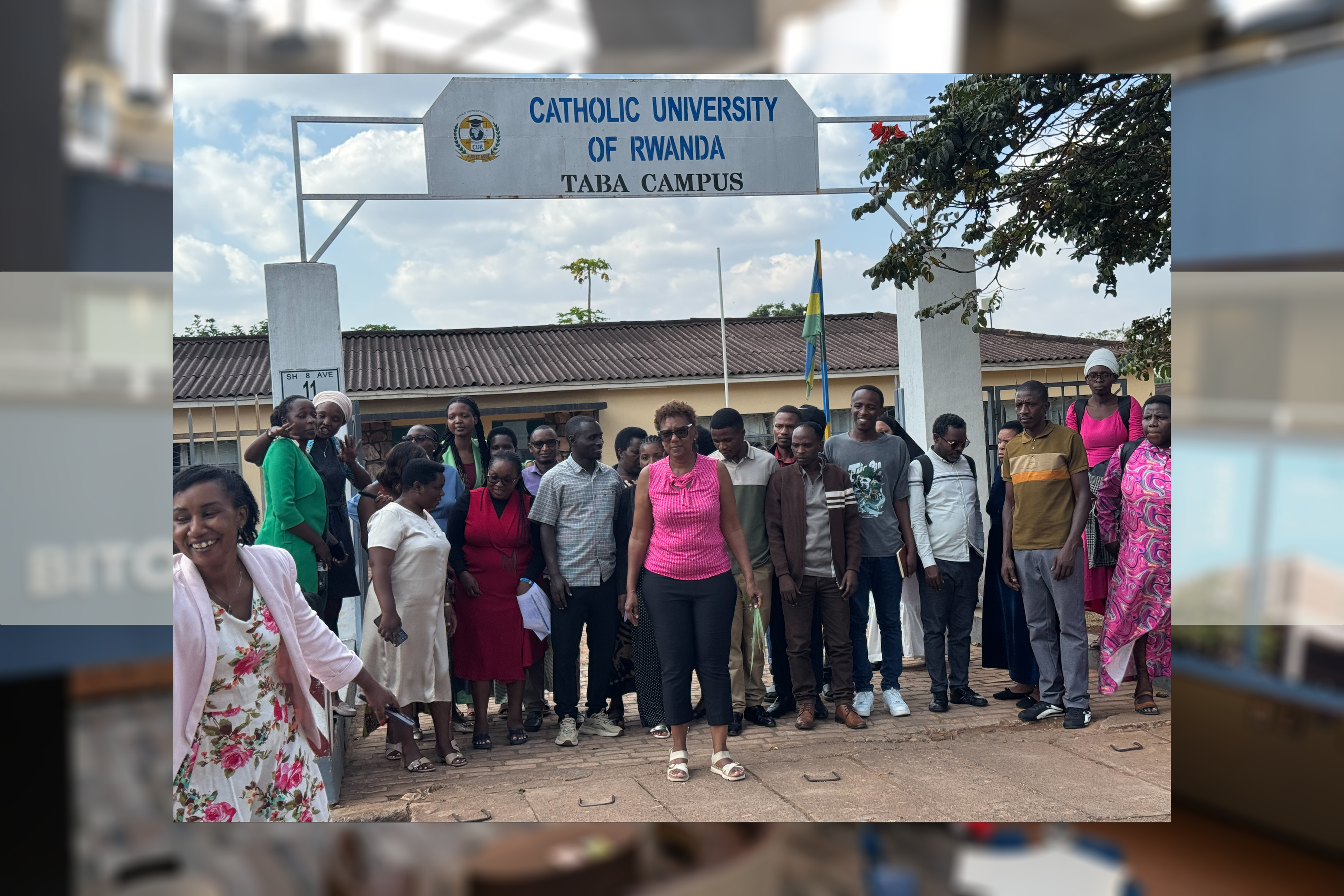 Sherri Harper Woods with Catholic University of Rwanda students at the gates of the university