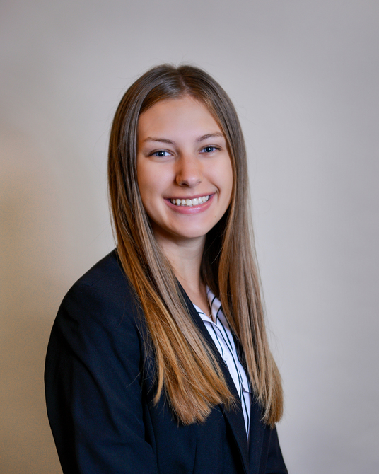 Photo of Emilee Smrek smiling in front of plain white wall