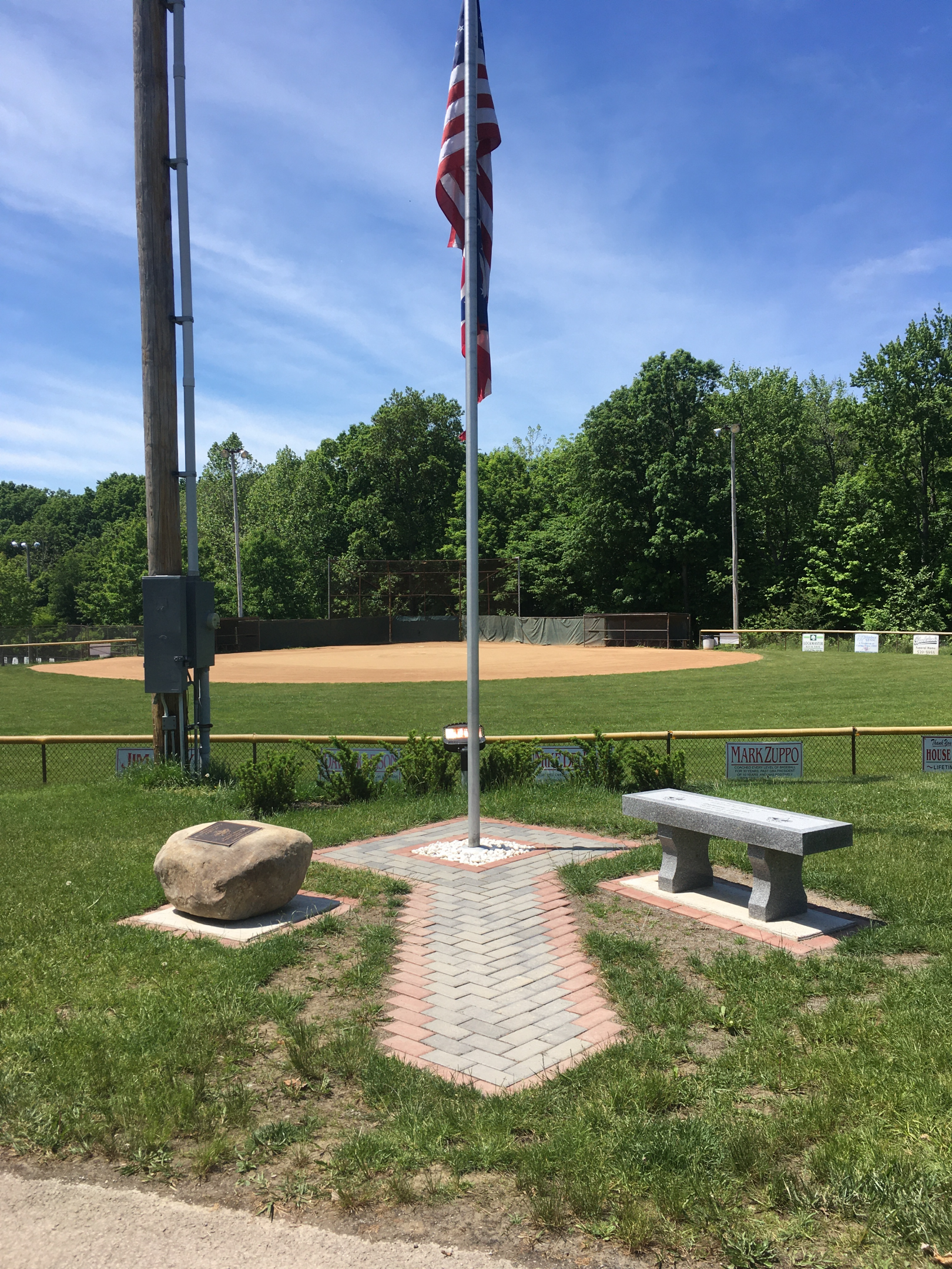 US Flag on pole in front of baseball field