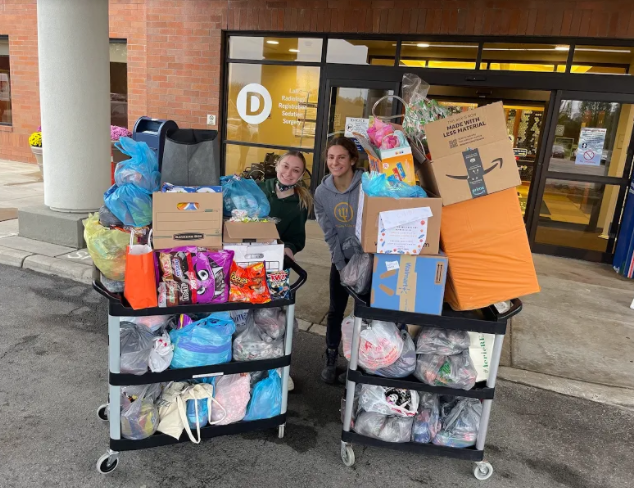 Jacqueline pushing huge cart of candy for Akron Children's Hospital with friend Alexis