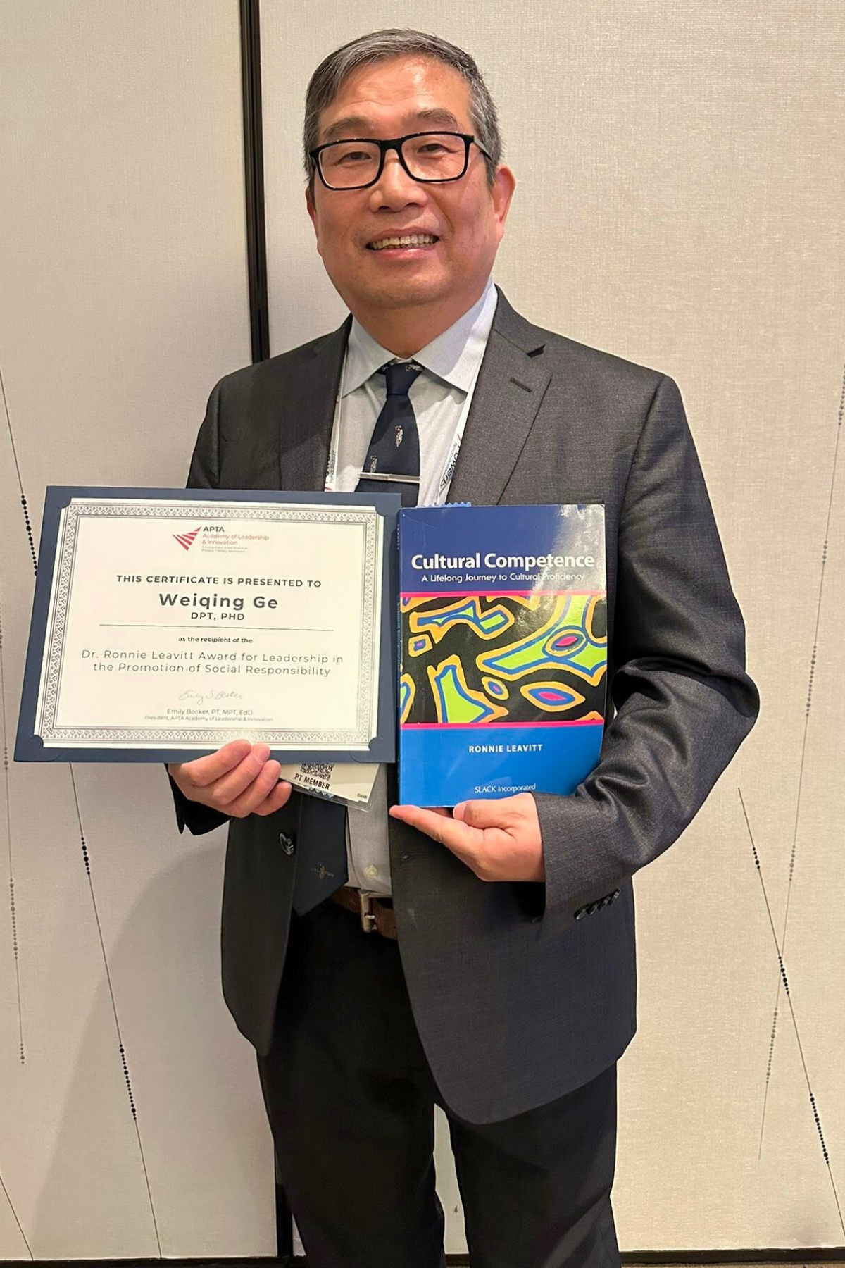 Weiqing Ge poses with the Dr. Ronnie Leavitt Award for Leadership in the Promotion of Social Responsibility from the American Physical Therapy Association Academy of Leadership and Innovation