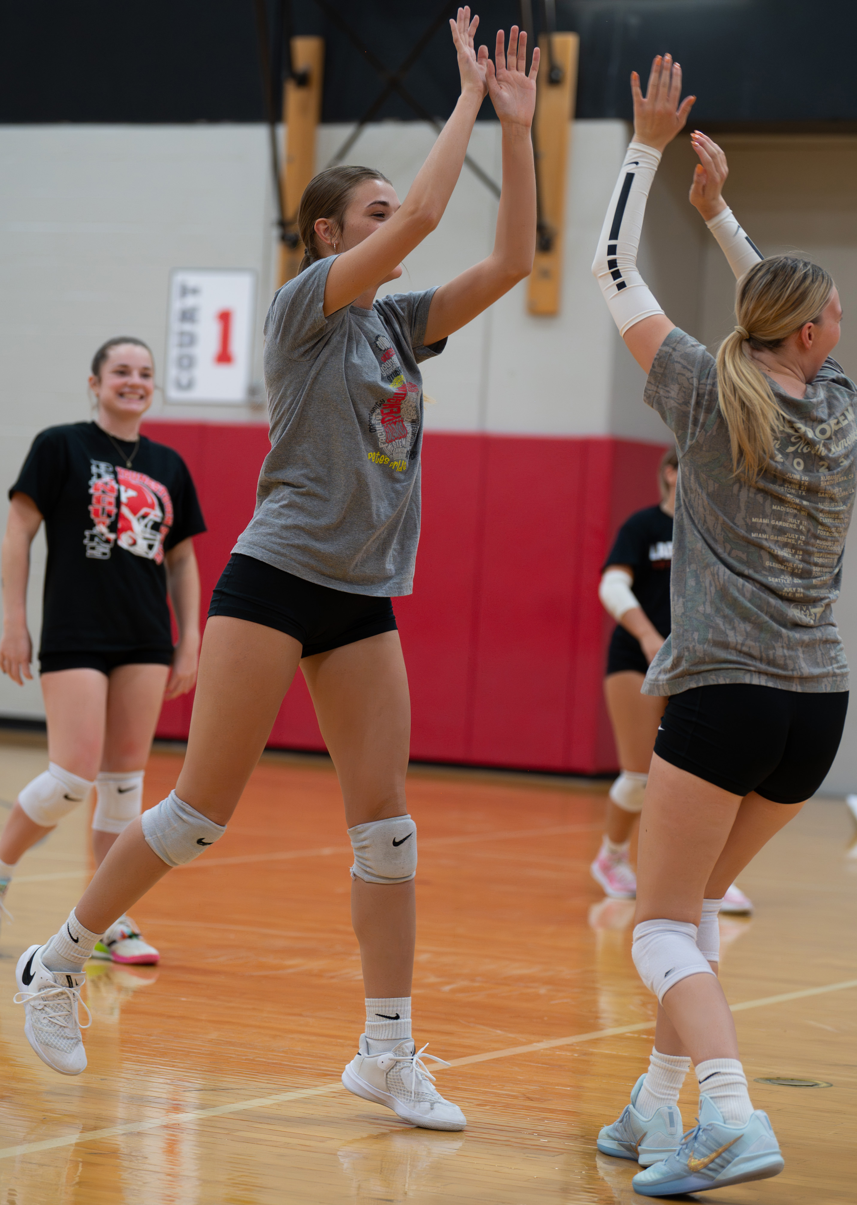 Cailey Wellman high-fiving a teammate at Volleyball practice