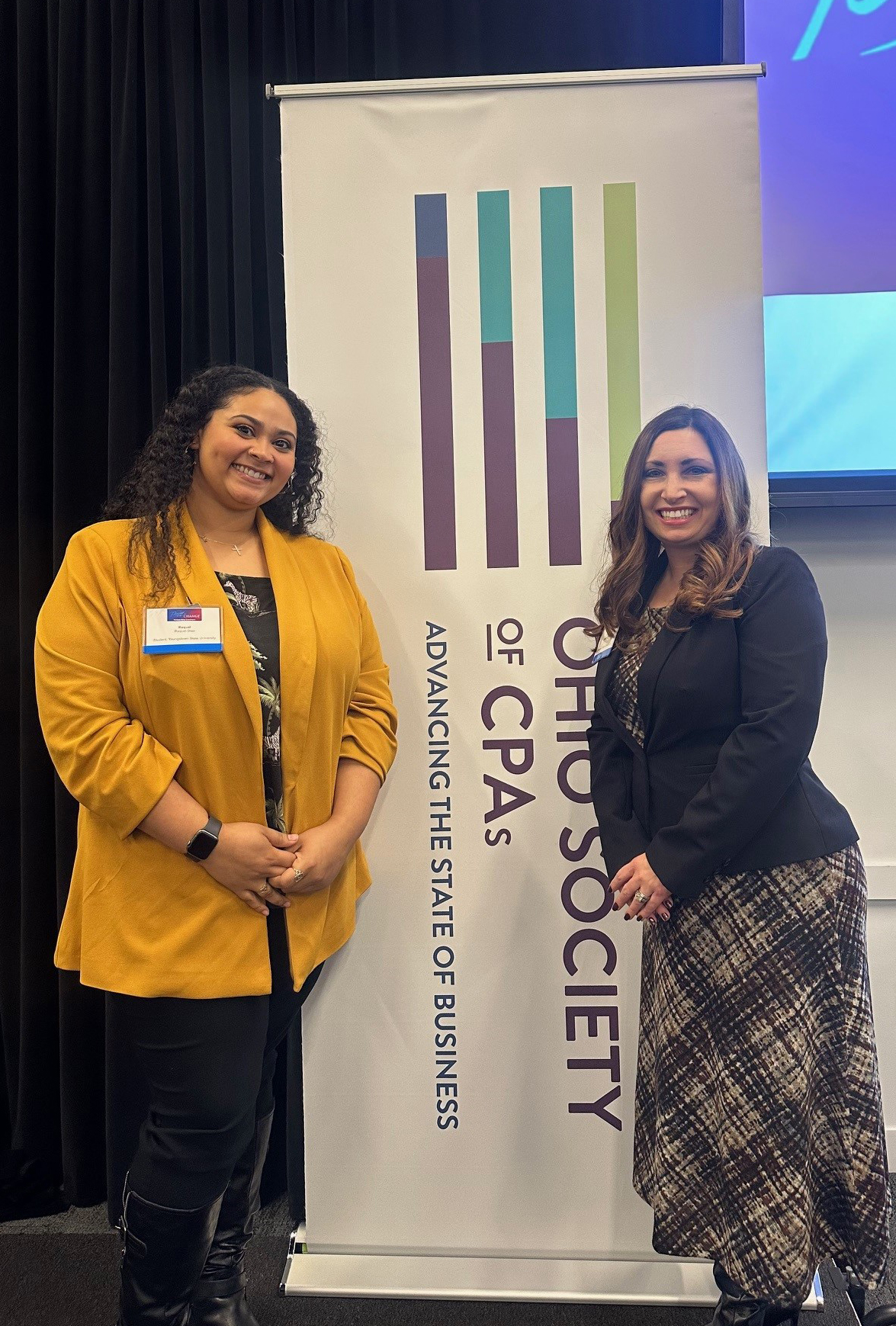 Accounting student Raquel K. Diaz-McClendon and Jessie Wright, assistant professor of accounting pose in front of a banner for the Ohio Society of CPAs