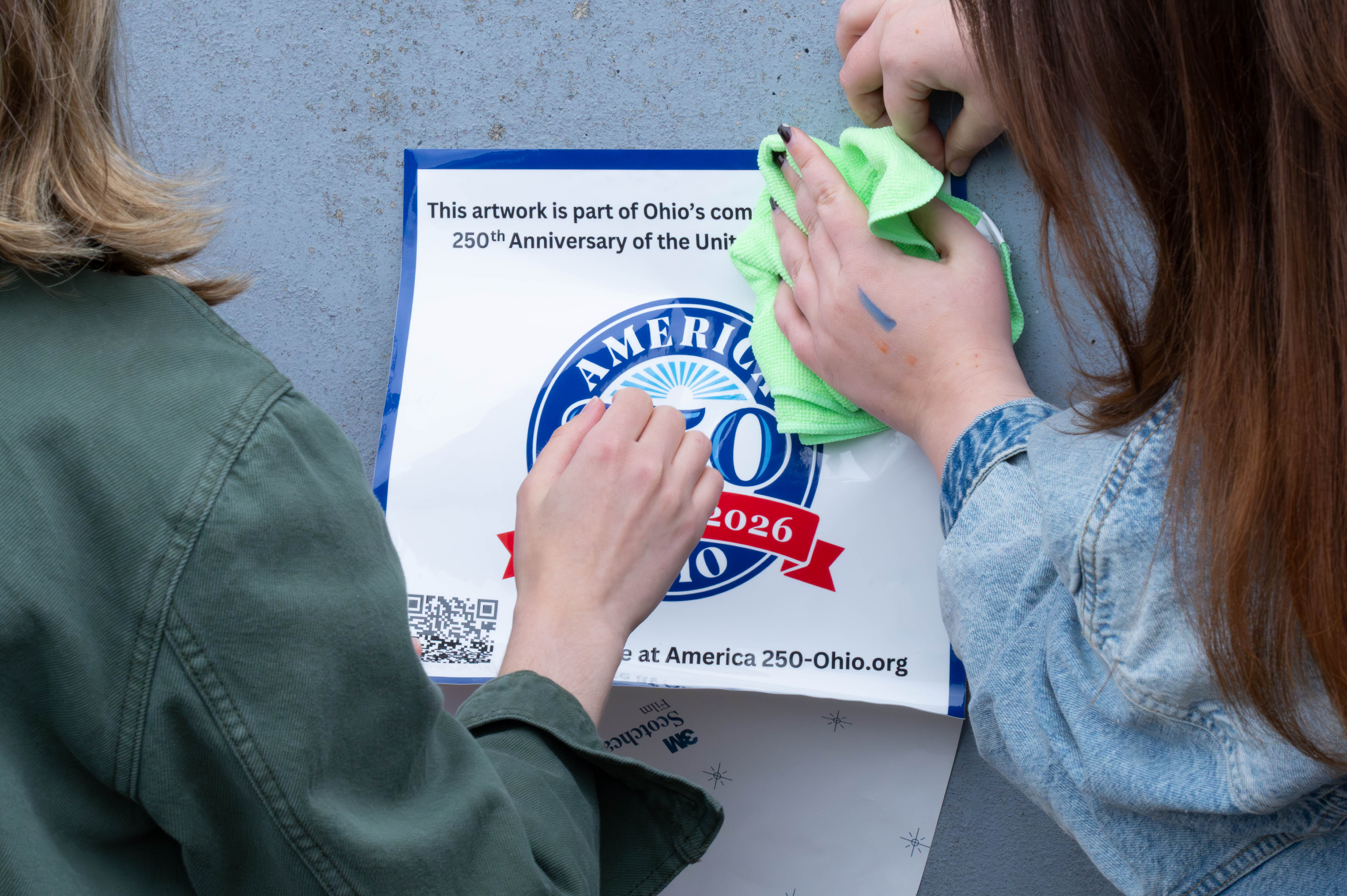 A photo of the America 250–Ohio decal being applied to the Adrews Ave. mural
