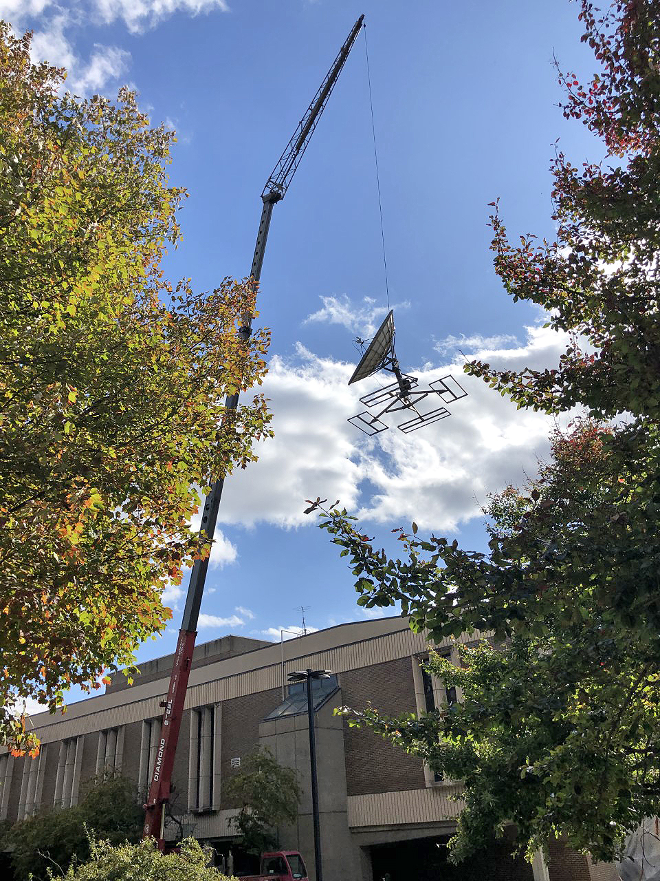  a giant crane removing old, outdated communications dishes and other equipment from the roof of Cushwa Hall.
