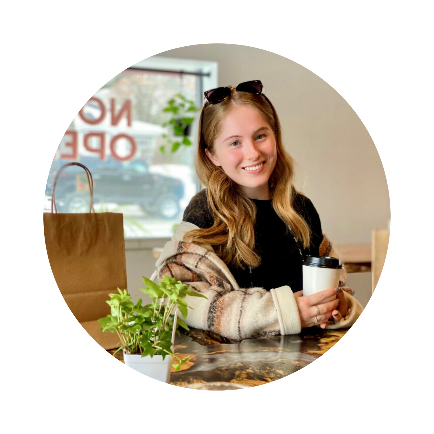 Faith Marscio poses at a table in a coffee house