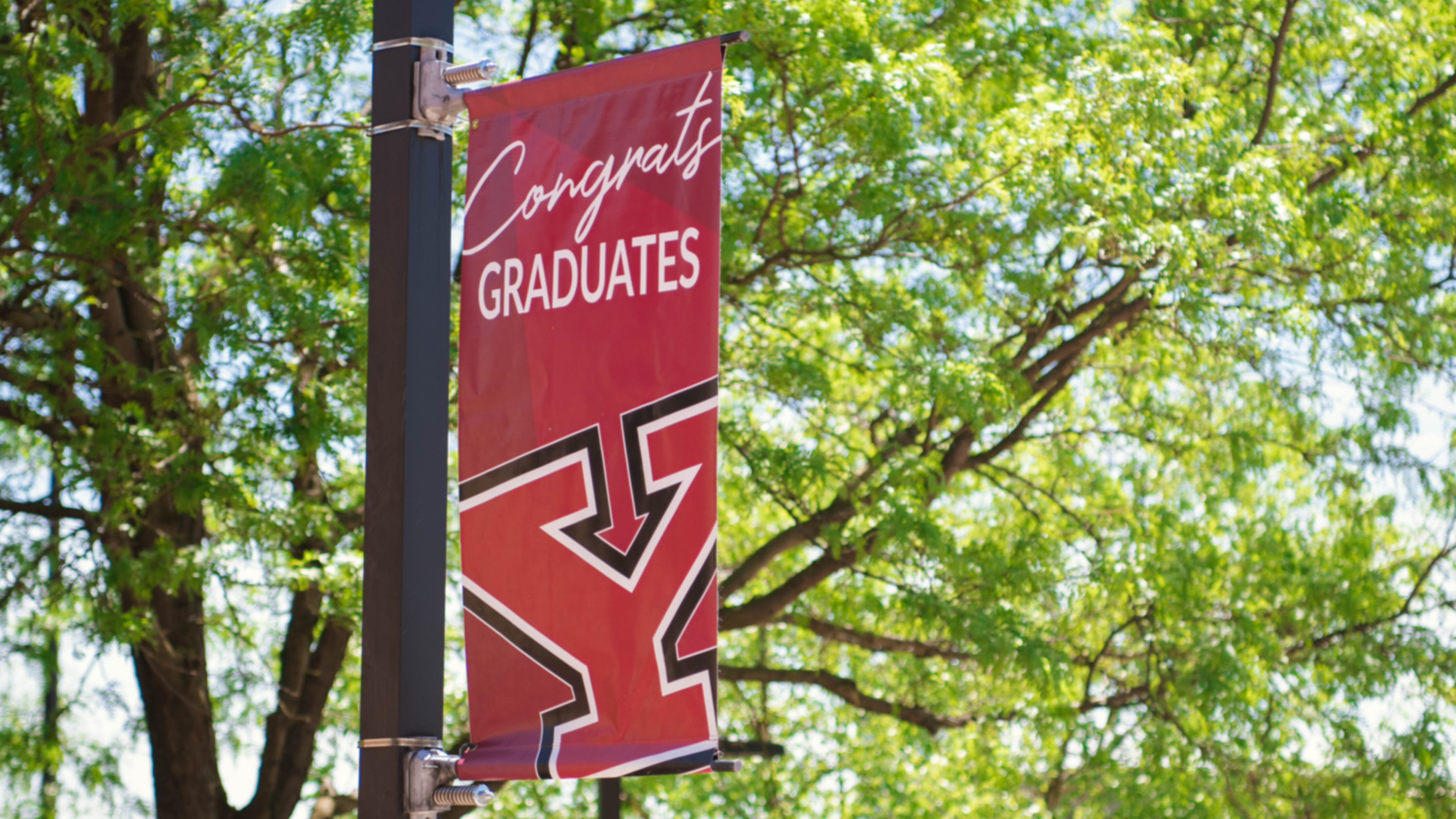 A banner on a pole reads "congrats graduates!"