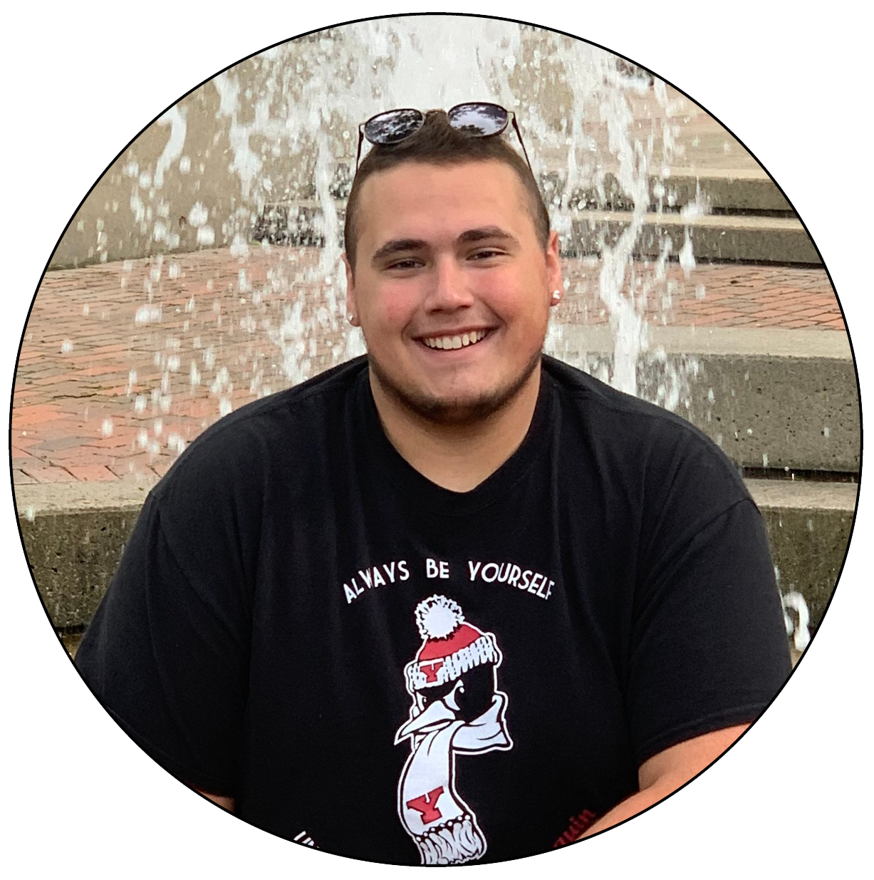 Mario Campalong sits on the side of the fountain at Youngstown State University