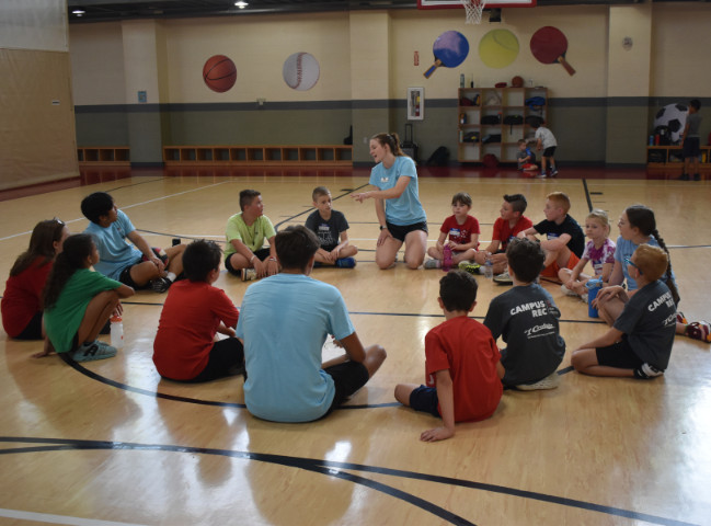 Counselors and campers sitting in a circle talking about their next camp activity