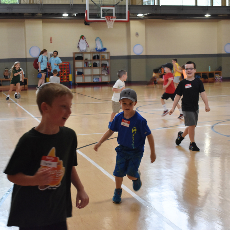 Young children running on courts at summer camp