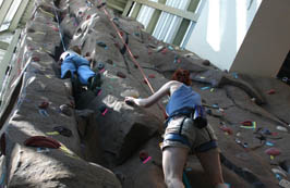 Students climbing rock wall in rec center