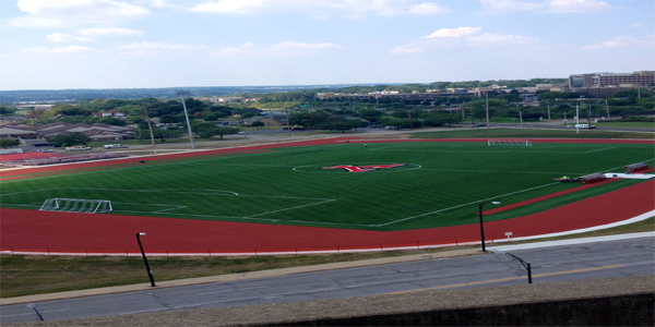 View of turf soccer field with track surrounding field.