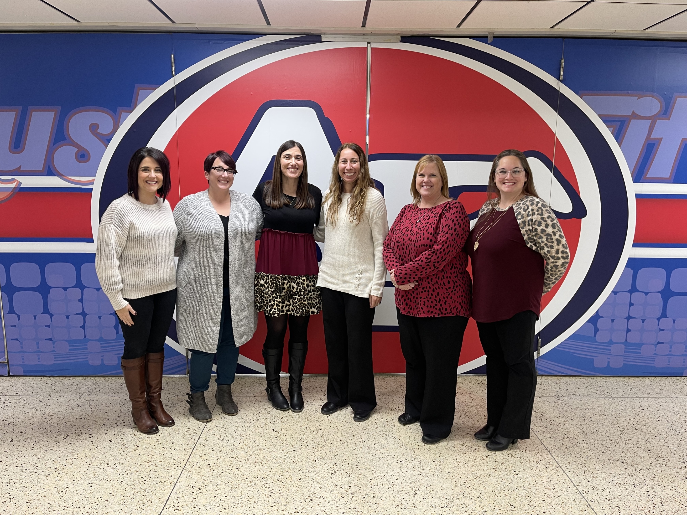 Austintown CCP Instructors smiling in front of Austintown Fitch High School mural