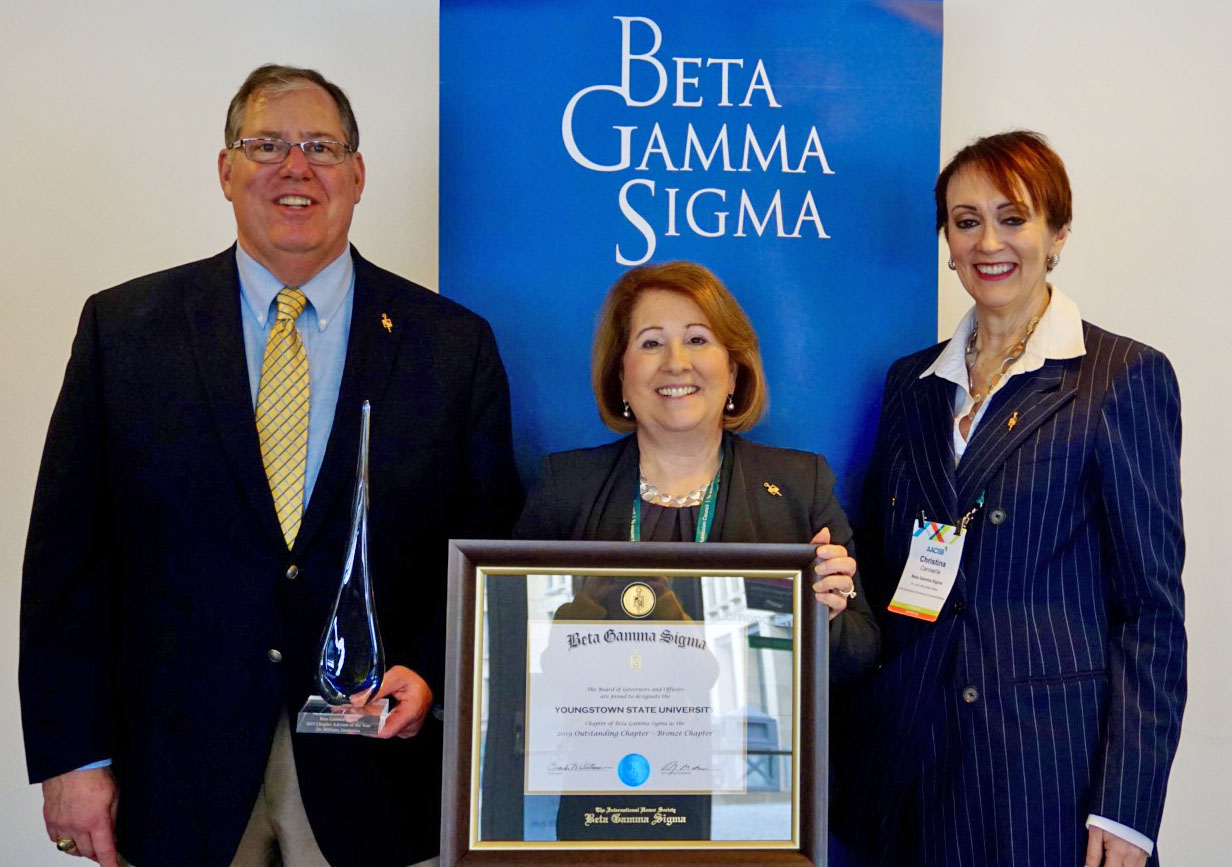 William Vendemia, left, professor of Management, received the international Beta Gamma Sigma Chapter Advisor of the Year Award, and Betty Jo Licata, dean of the YSU Williamson College of Business Administration, accepted the Bronze Outstanding Chapter Award. On the right is Christine Carosella, chief executive officer of BGS.