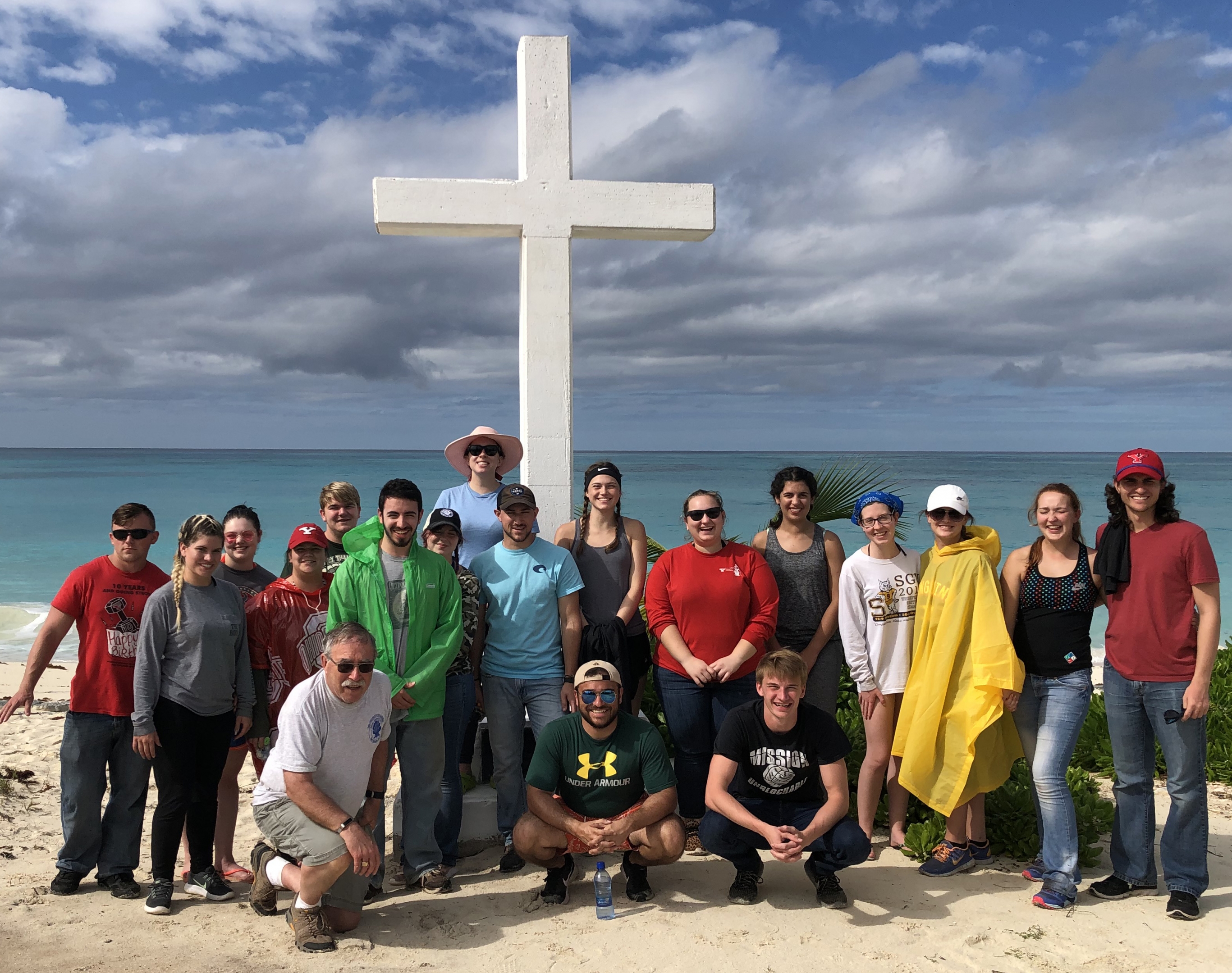 Ron Shaklee, professor and chair of Geography and Urban-Regional Studies, pictured kneeling with YSU students in San Salvador, Bahamas. This week, Shaklee is in the Bahamas for his 31st study abroad trip to the island