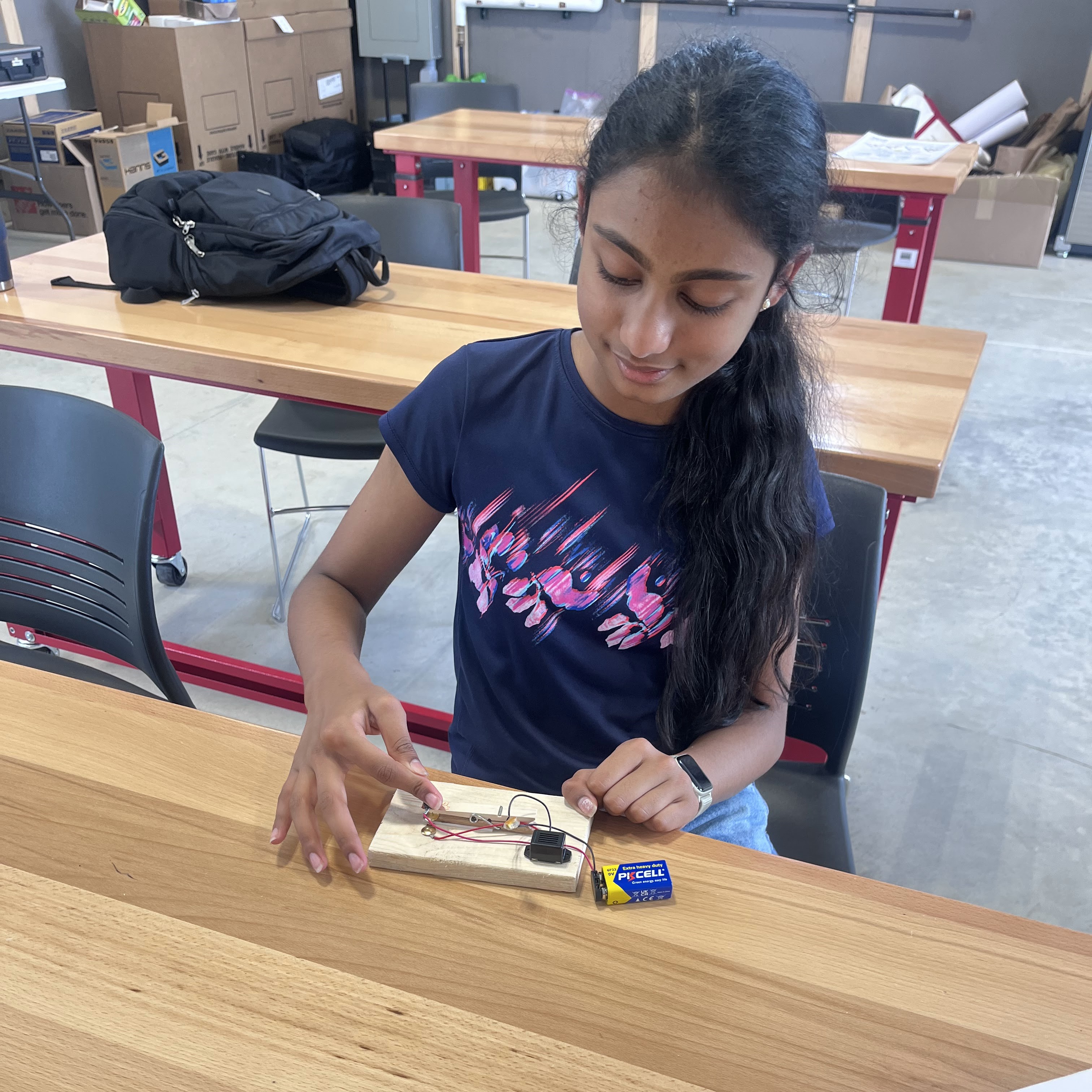 Girl sitting at table with home-made telegraph