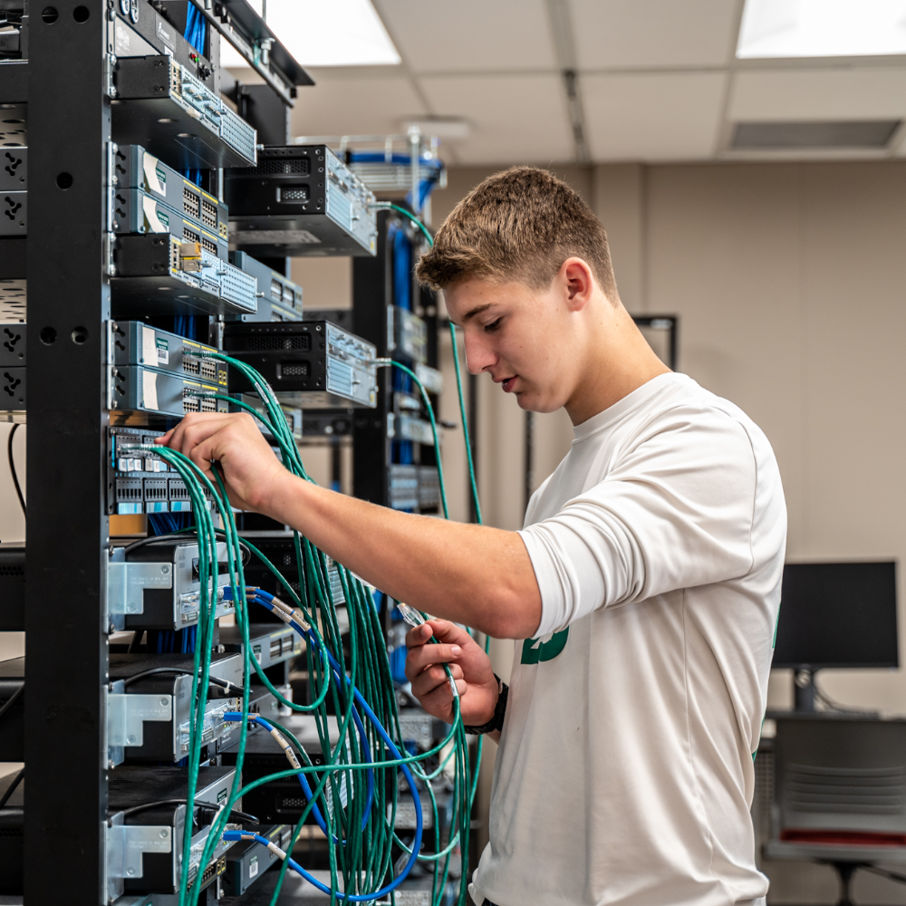 IT student in front of servers thinking