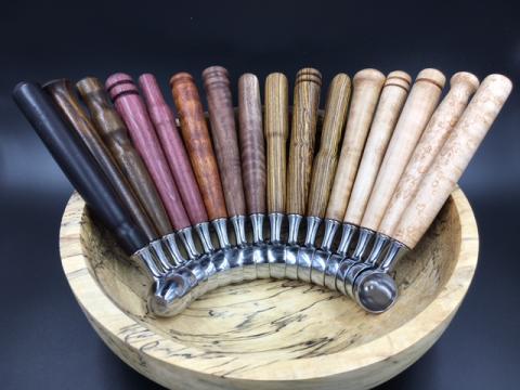 Wood pieces of different colors with a metal scoop on the end