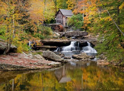 A photo of the mill at Mill Creek Park in Youngstown Ohio during the fall with the leaves different colors