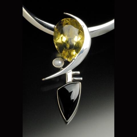 A gold, black, and silver pendant
