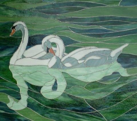 A stained glass portrait of two swans swimming together in a pond
