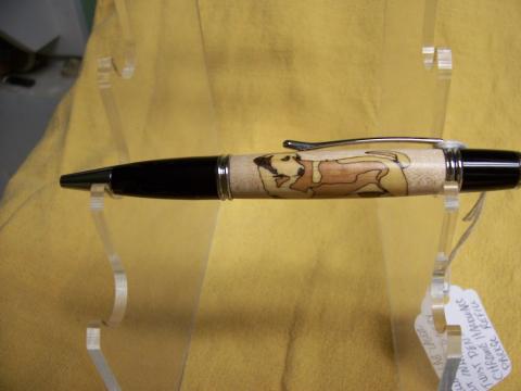 A wooden pen with a dog carved in the side
