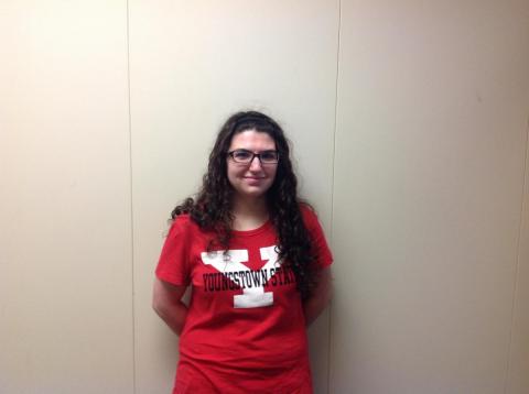 Female student wearing a red Youngstown State t-shirt posing against a white wall