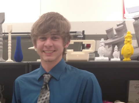 A smiling male student posing in a lab