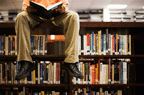a student sitting on a bookshelf
