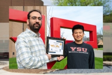 Aydin Ulus and Kyosung Choo pose on the YSU campus with Ulus's first place certificate