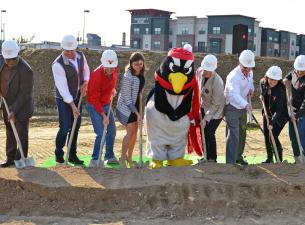 university officials and others grabbed golden shovels and donned Penguin hard hats to break ground 