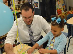 David Tharp, human resources manager at Alta Head Start, works on a puzzle with a child at the new H