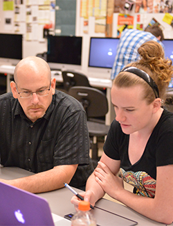 ysu professor helping student with assignment in computer lab